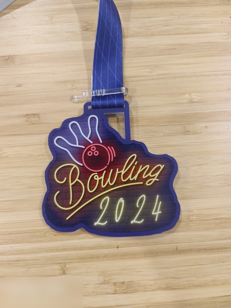 Medal Bowling 2024 bergaya PAPAN TANDA NEON. Bentuk custom bebas, latar dinding bata gelap dgn tulisan neon kuning menyala dan bola bowling merah neon. Bingkai biru. Reben biru. Contoh design retro/ne