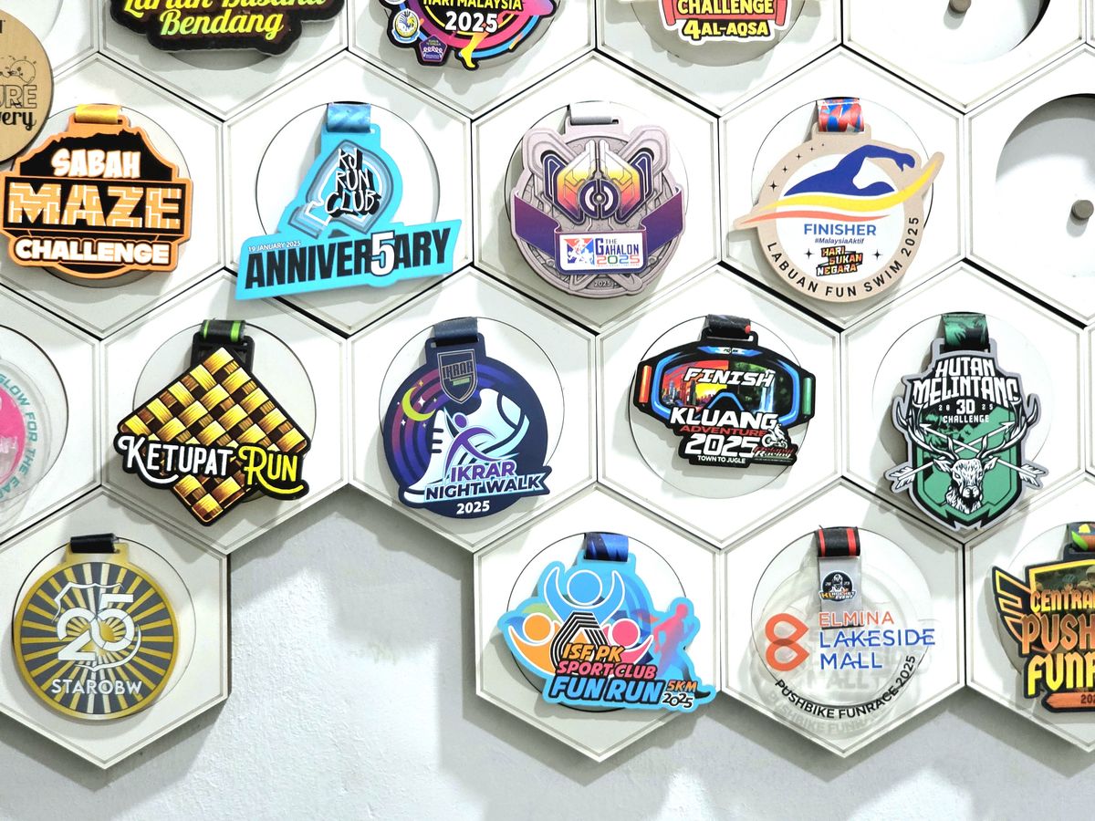 Pandangan dekat dinding galeri: medal Sabah Maze Challenge, Anniversary, Ketupat Run, Ikrar Night Walk 2025, Finish Kluang 2025, Labuan Fun Swim dan Aina Lakeside Mall.
