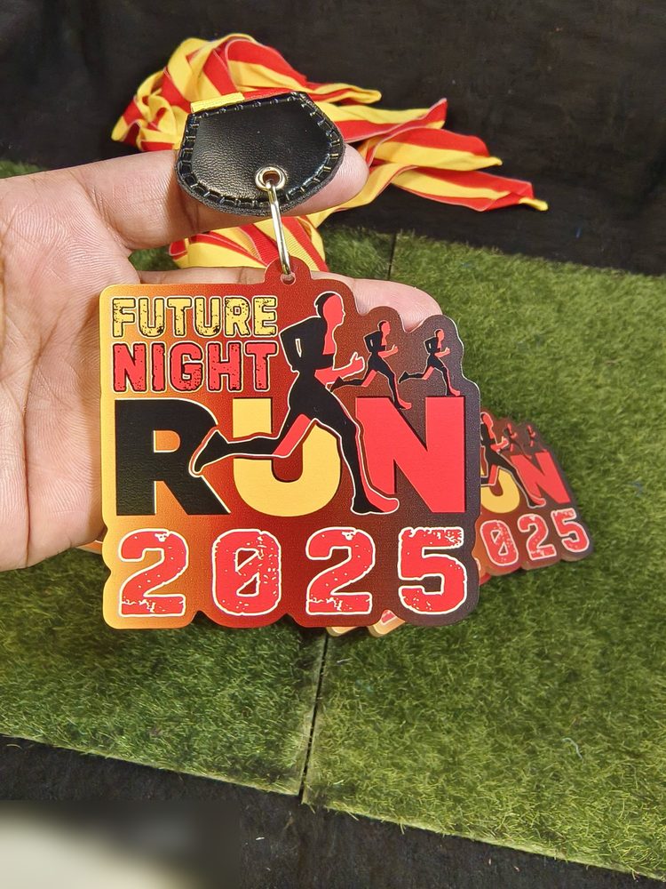 Medal Future Night Run 2025 — larian waktu malam. Bentuk custom dgn teks 'RUN' besar dan tiga silhouette pelari, gradasi MERAH-OREN-KUNING seperti api. Reben merah-kuning dgn tab kulit hitam. Angka '2