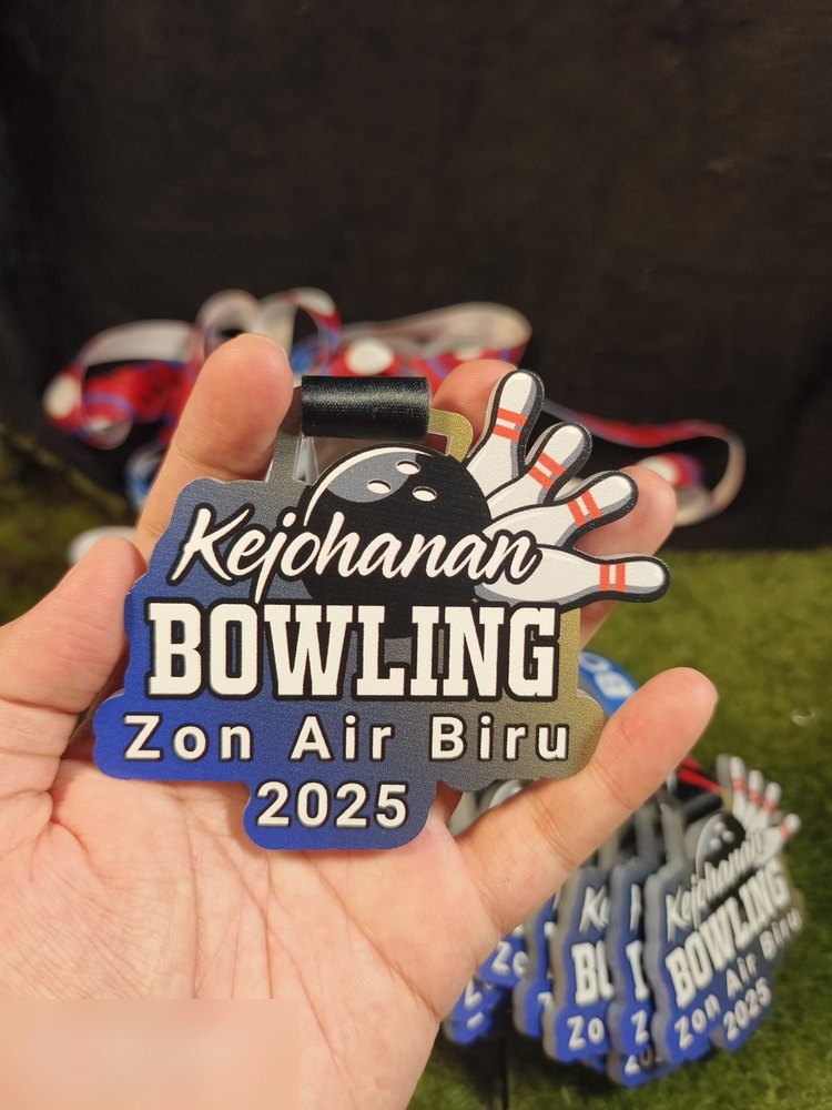 Medal Kejohanan Bowling Zon Air Biru 2025 dlm kuantiti — tunjuk gradasi biru-emas konsisten merentas banyak keping, dgn lanyard merah-putih-biru bertompok.